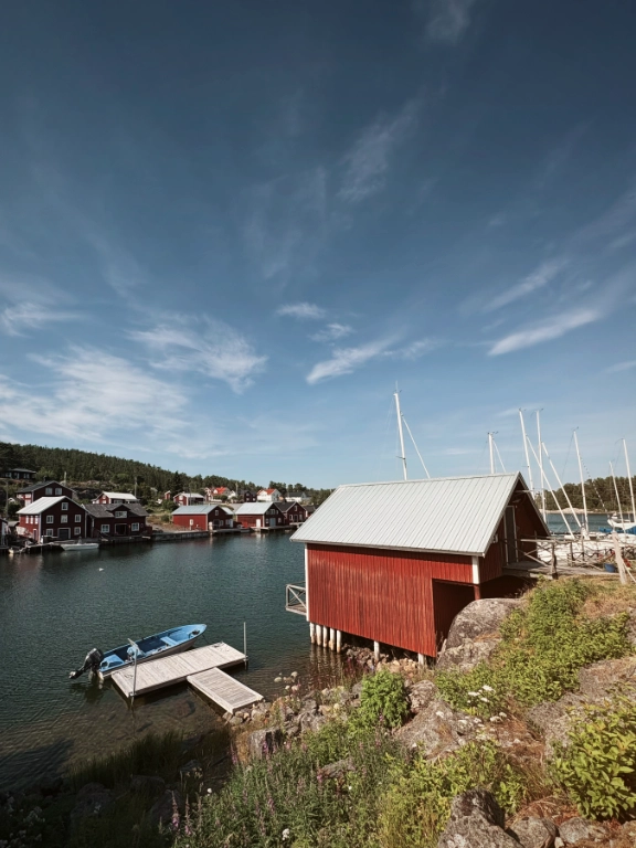 En hamn i Bönhamn med båtar och röda båthus.