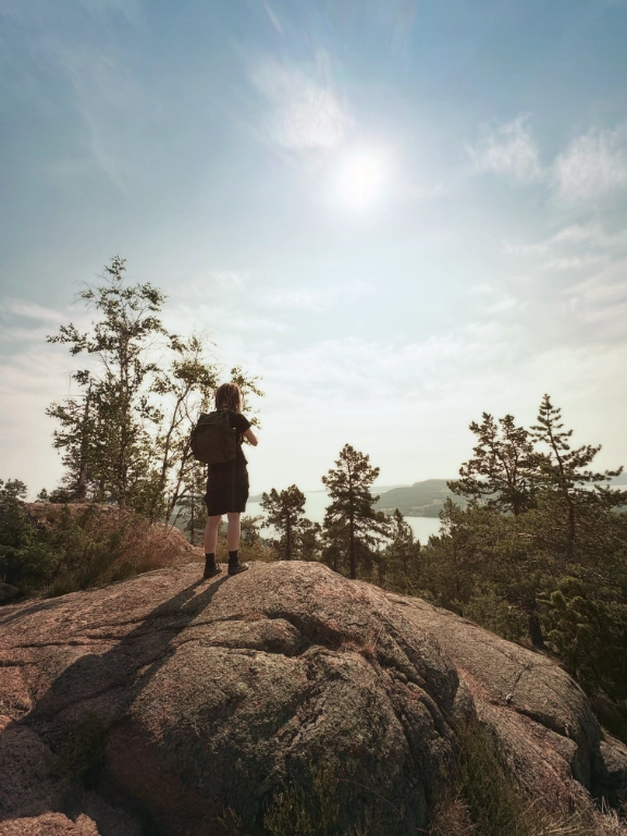 Eja står på en stor sten nära toppen på Skuleberget.