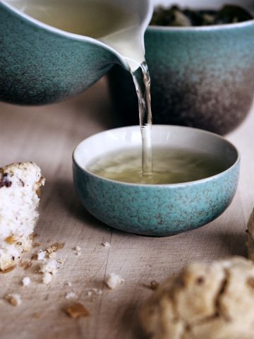 Te hälls upp i en kopp från en gaiwan.