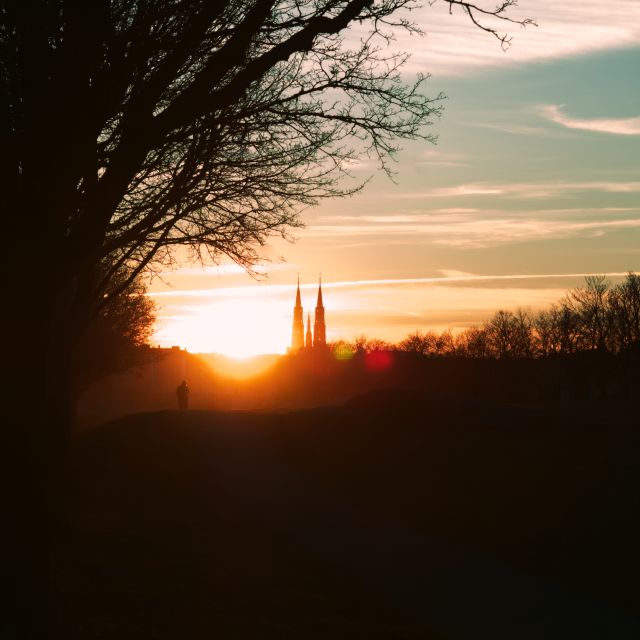 En varm solnedgång med en Uppsala domkyrka i bakgrunden.